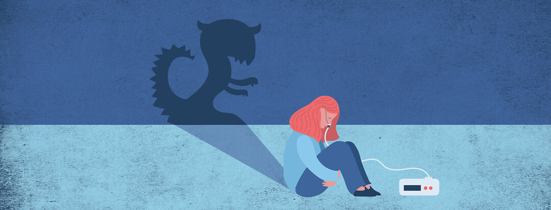 A woman with an CPAP machine sitting on the floor hugging knees with her head bowed, casting a monster shaped shadow