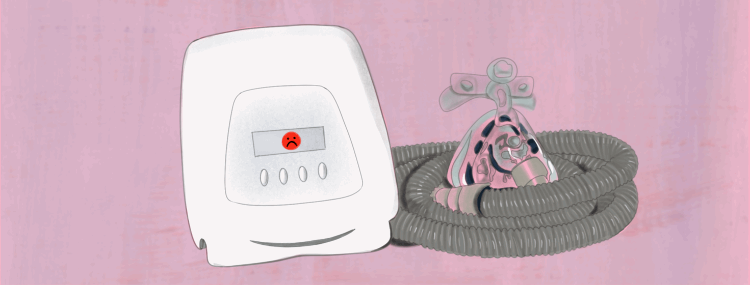 A CPAP machine's display flashes and red frowny face